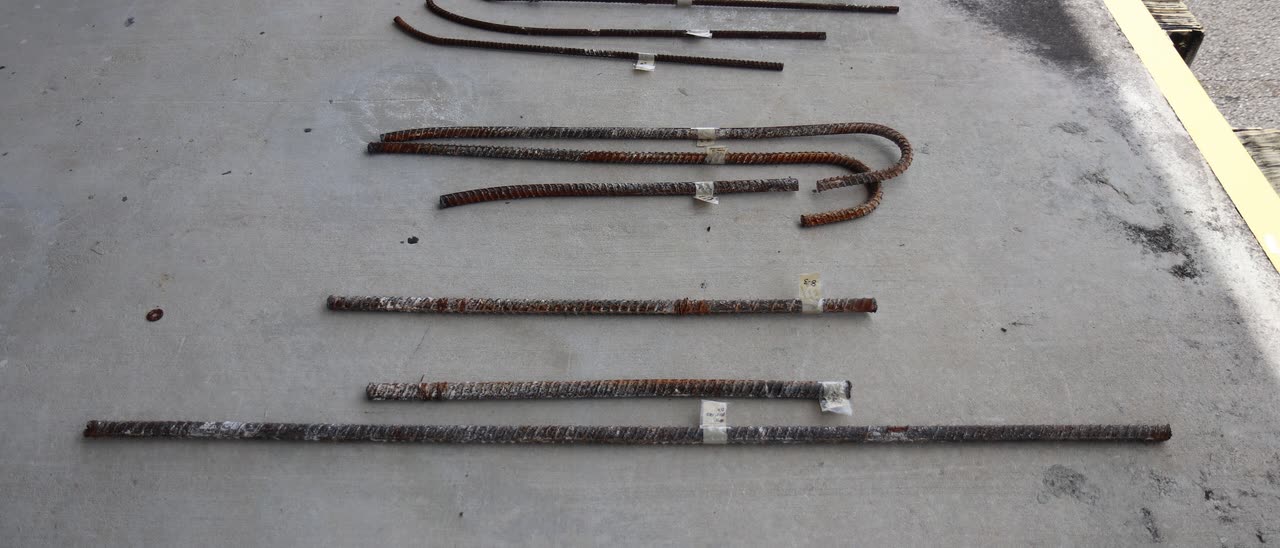 Steel reinforcing bars recovered from the collapsed FIU pedestrian bridge, laid out and tagged on a concrete floor